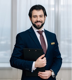 handsome hotel administrator with clipboard looking at camera